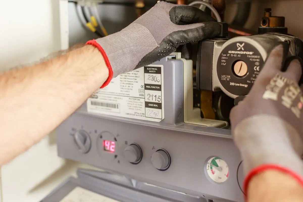 Monteur arbeitet an einer geöffneten Gastherme